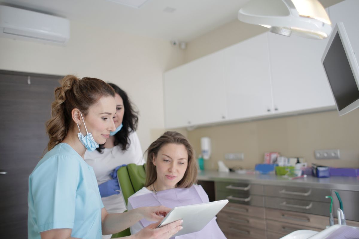 Dental team reviewing treatment options with a patient on a tablet